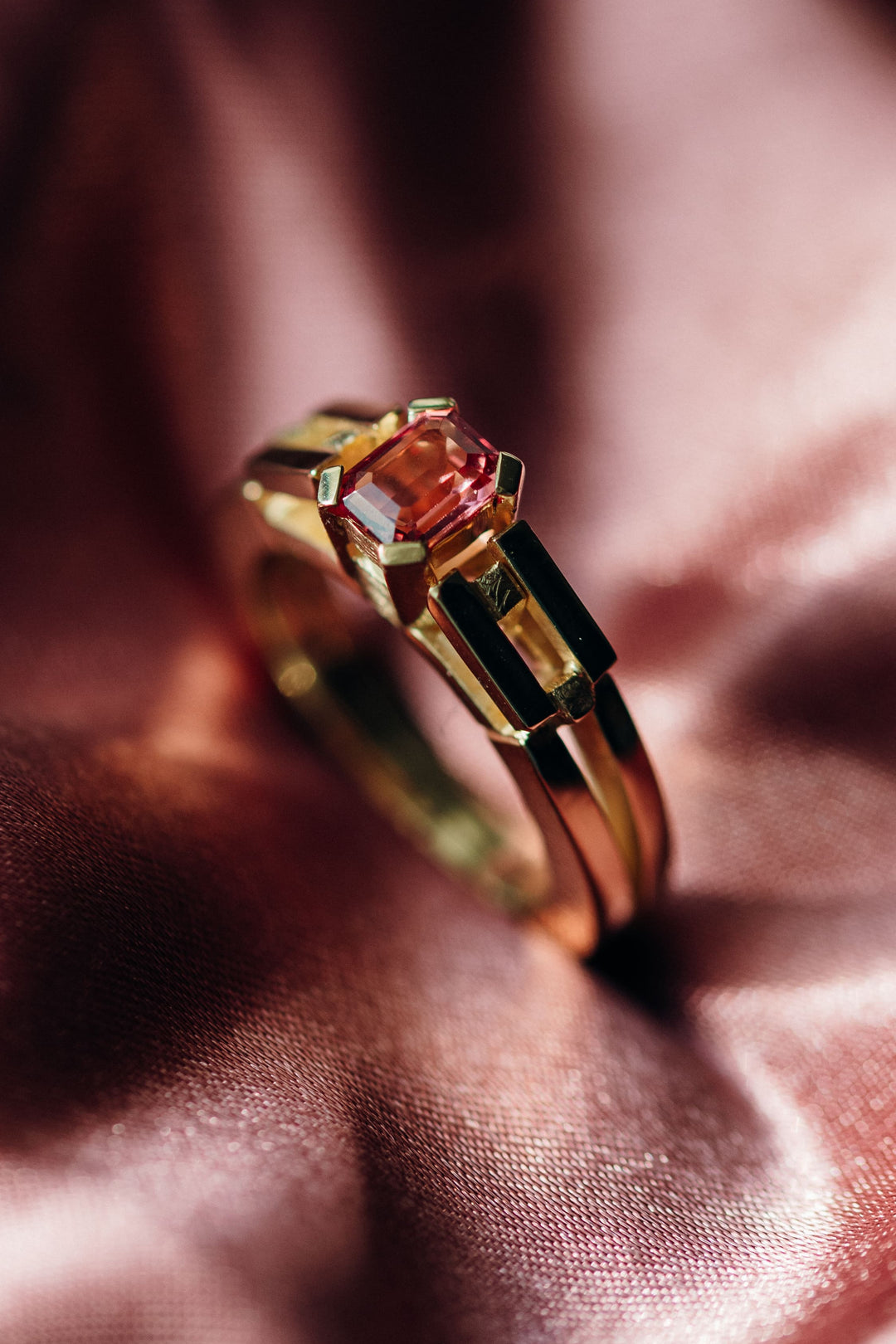 Le Pont Ring mit rosafarbenem Spinell in 18 K Gelbgold auf sanftem Stoffhintergrund