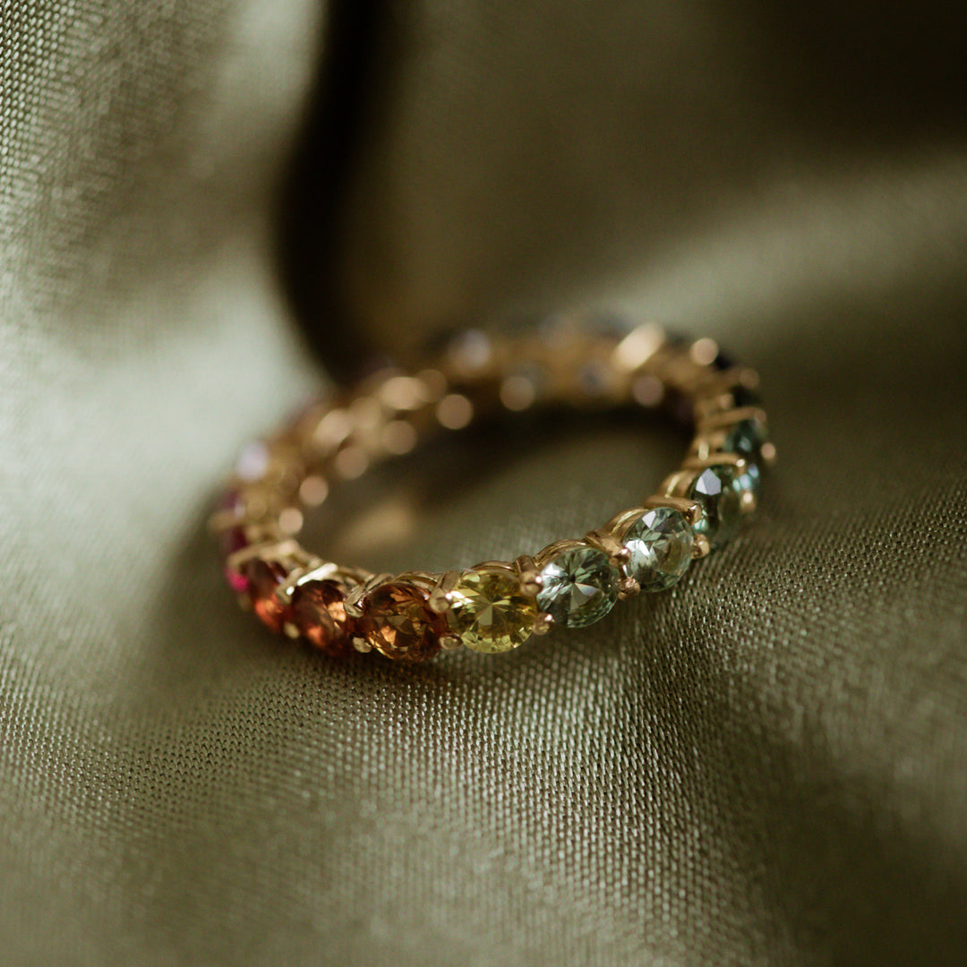 Rainbow 14 Karat Gelbgold Saphir Ring on green fabric