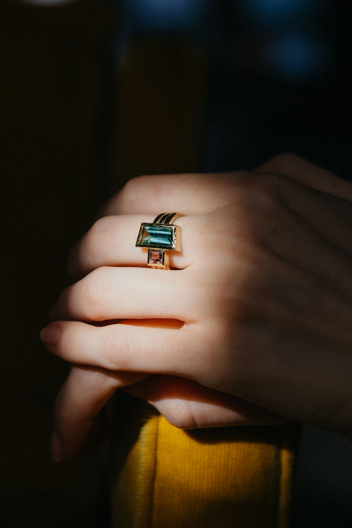 Mon Trésor Ring aus Gelbgold mit rechteckigem grünem Turmalin, kunstvoll im Spiel aus Licht und Schatten fotografiert.