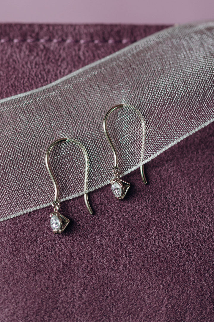 Filigrane Emilia Diamond Earrings aus Weißgold, deren Diamanten im Schwung schimmern.
