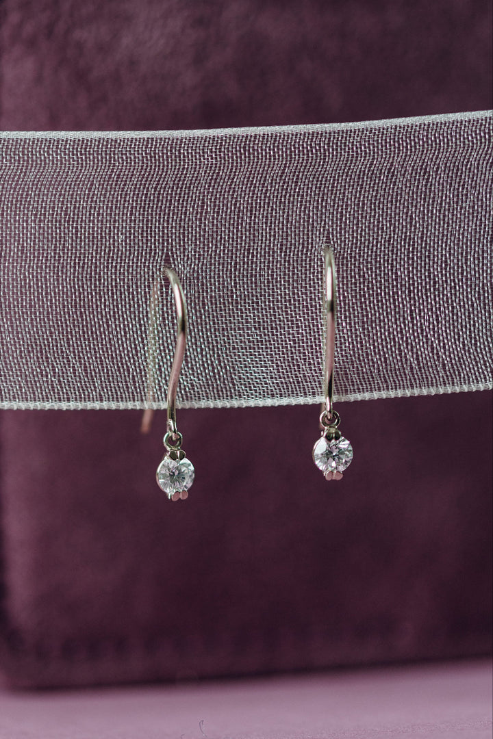 Emilia Ohrhänger aus Weißgold, deren Diamanten durch die geschwungene Form besonders viel Licht einfangen.