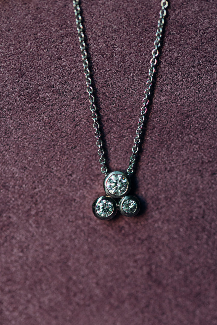 Gloria Collier mit drei brillantgeschliffenen Diamanten im geometrischen Dreier-Design, gefertigt in feiner Vollfassung auf einer zarten Kette.