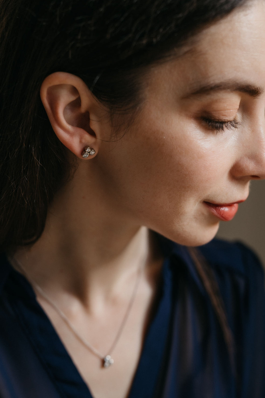 Profilaufnahme eines Modells mit den Gloria Ohrringen in Weißgold, zart funkelnd im natürlichen Licht.