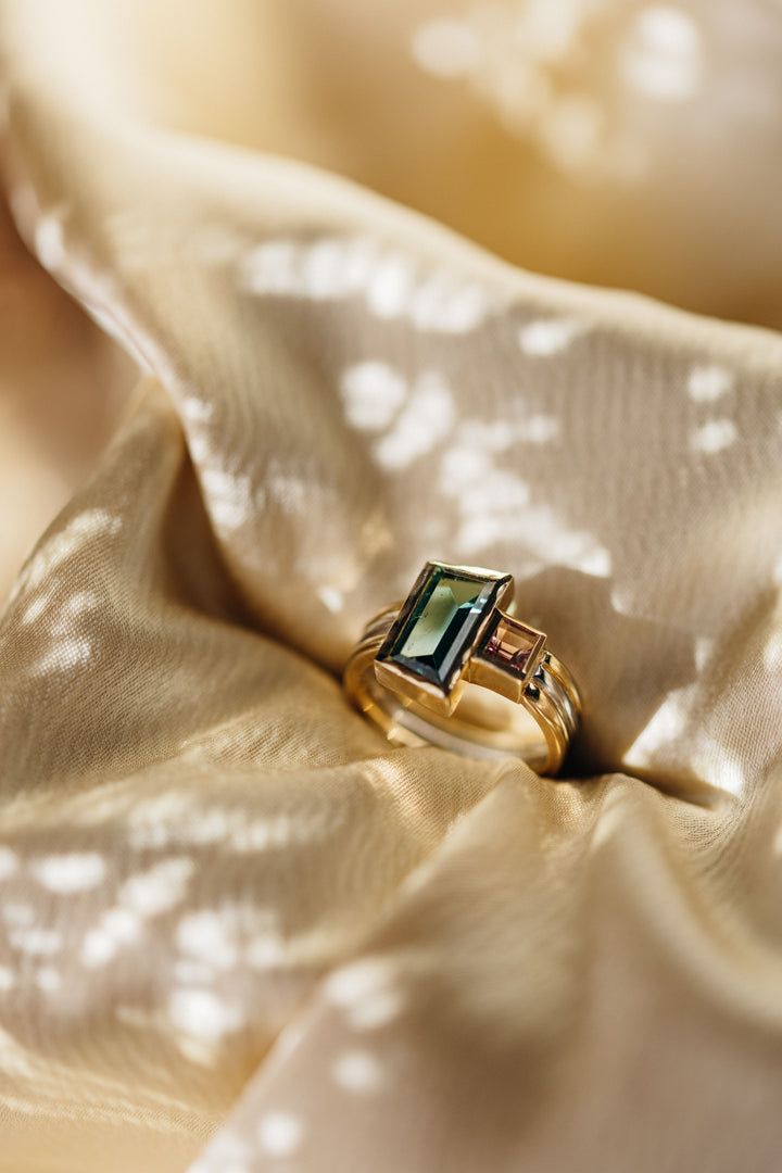 Le Trésor Designring mit Farbsteinen, fotografiert auf goldenem Stoff