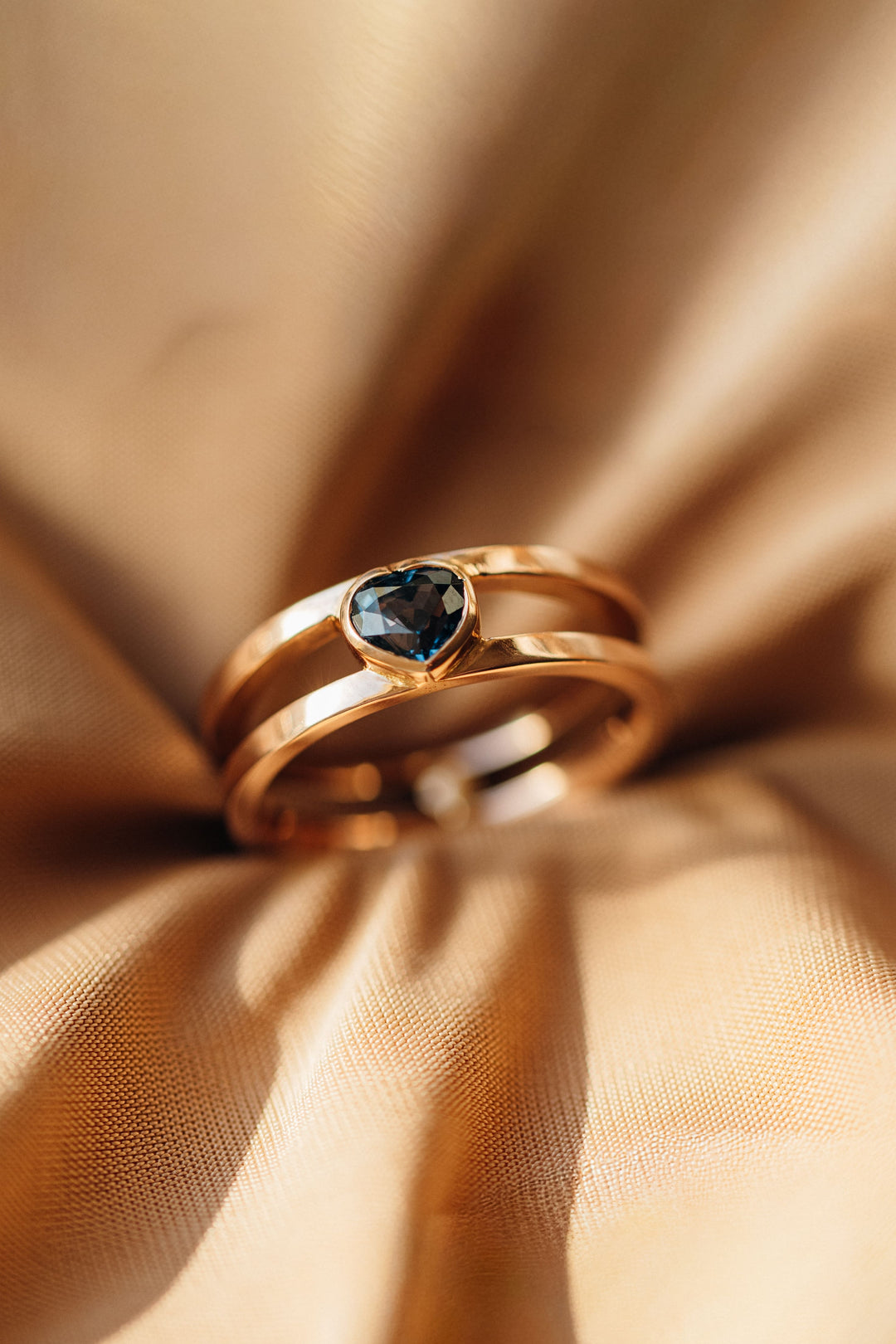 Nahaufnahme des Mon Cœur Rings mit blauem herzförmigem Spinell in Roségoldfassung