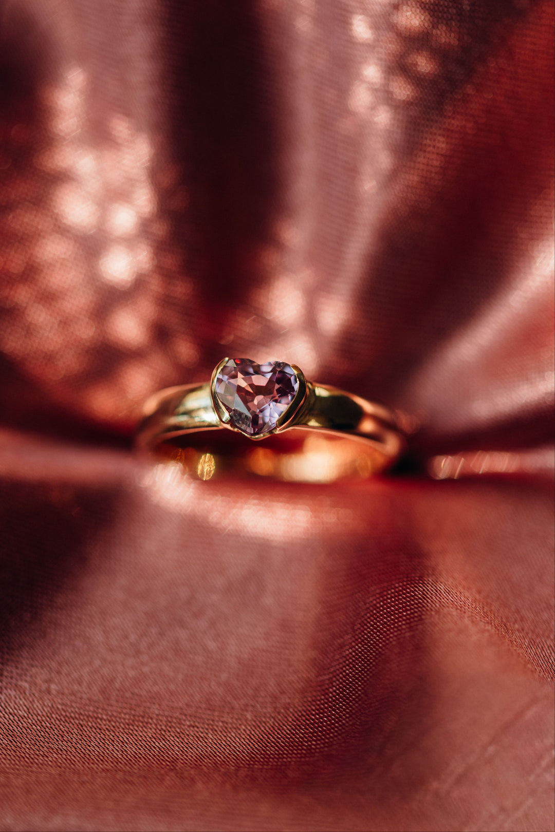 Nahaufnahme des herzförmigen rosafarbenen Spinells im Mon Cœur Ring auf roségoldenem Hintergrund